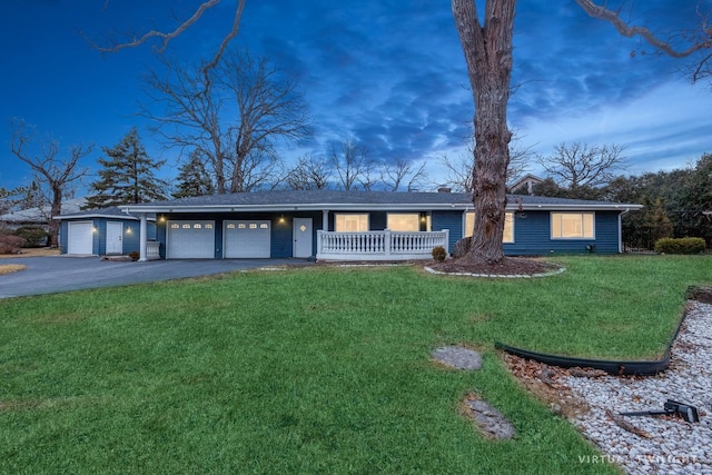 ranch-style home featuring a garage and a yard