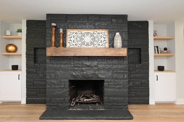 interior details featuring built in shelves, wood-type flooring, and a fireplace