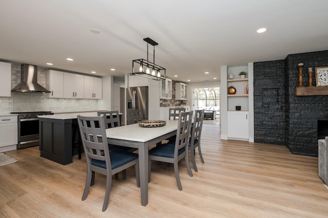 dining room featuring a fireplace and light wood-type flooring