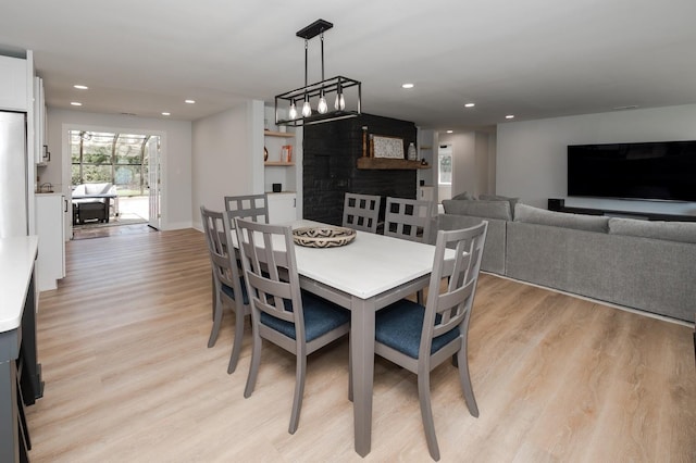 dining room featuring a fireplace and light wood-type flooring