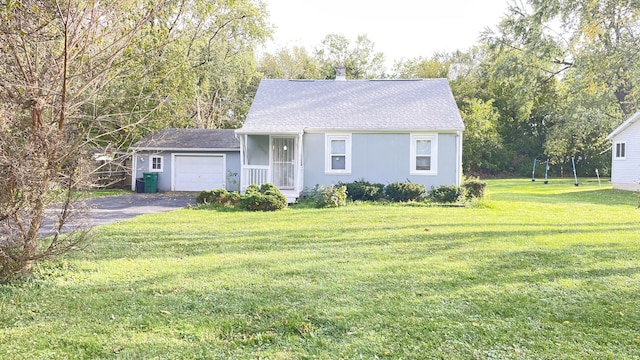 view of front of house with an attached garage, a shingled roof, a front lawn, and aphalt driveway