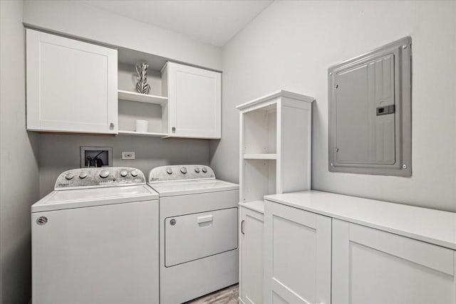 washroom with electric panel, separate washer and dryer, and cabinets