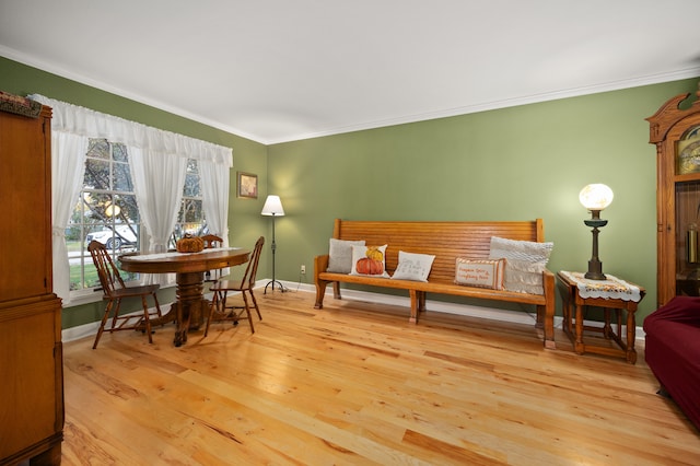 living area with light wood-type flooring and ornamental molding