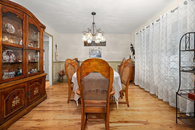 5995 W Clare Rd, Clare, IL 60111 - dining room featuring a chandelier, light wood-style floors, and a wainscoted wall