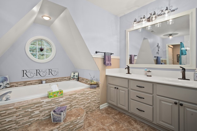 bathroom featuring a relaxing tiled tub, tile patterned flooring, and vanity