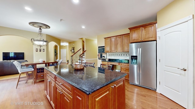 kitchen featuring pendant lighting, a center island, light wood-type flooring, and stainless steel fridge