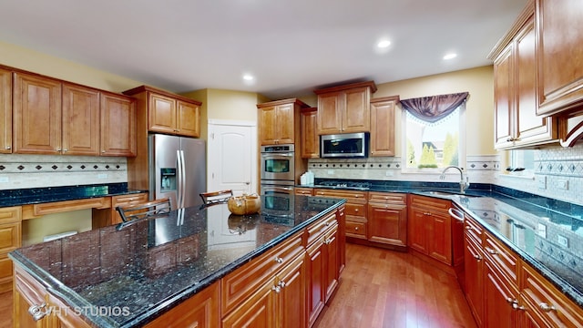 kitchen featuring tasteful backsplash, appliances with stainless steel finishes, sink, and a kitchen island