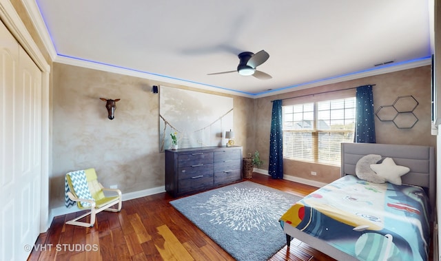 bedroom featuring dark hardwood / wood-style flooring, ornamental molding, a closet, and ceiling fan