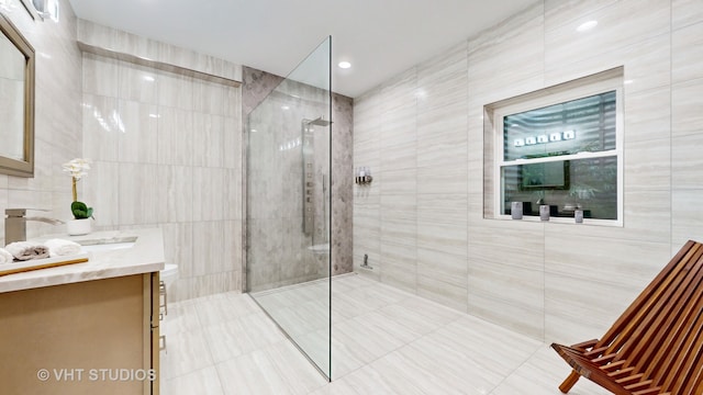 bathroom with vanity, tile walls, and an enclosed shower