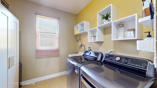 clothes washing area featuring light tile patterned flooring, sink, and washer and clothes dryer