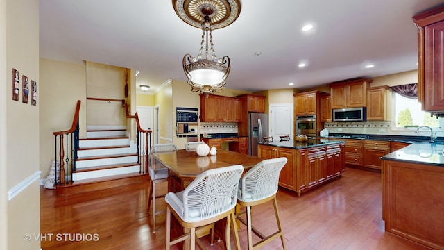 kitchen with tasteful backsplash, dark hardwood / wood-style flooring, a kitchen island, sink, and stainless steel appliances