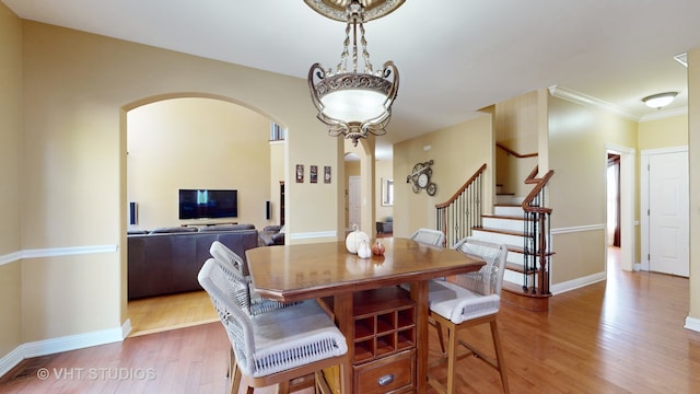 dining space with crown molding and hardwood / wood-style flooring