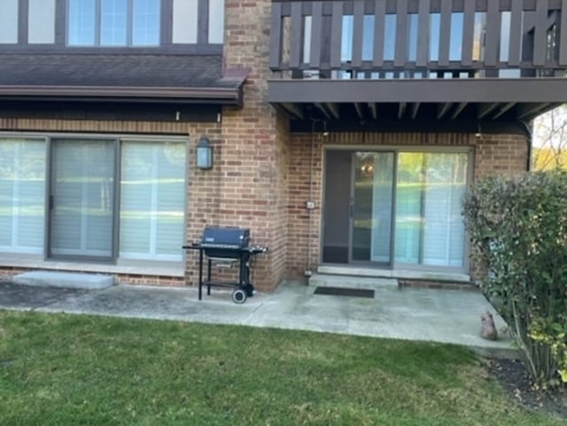 rear view of property with a balcony, a yard, and a patio area