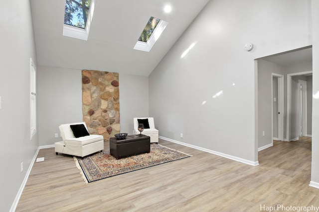 sitting room with high vaulted ceiling and light wood-type flooring