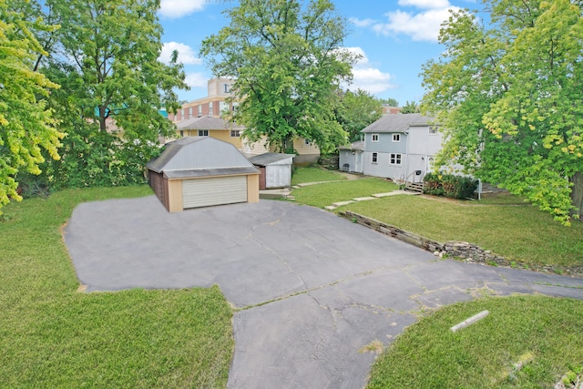 view of front of house with a front yard, an outbuilding, and a garage