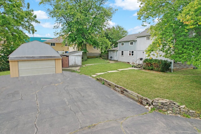 view of front of property featuring a front lawn, an outbuilding, and a garage