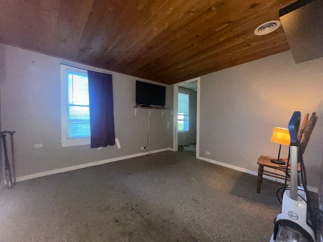 unfurnished room featuring wood ceiling, lofted ceiling, and dark carpet