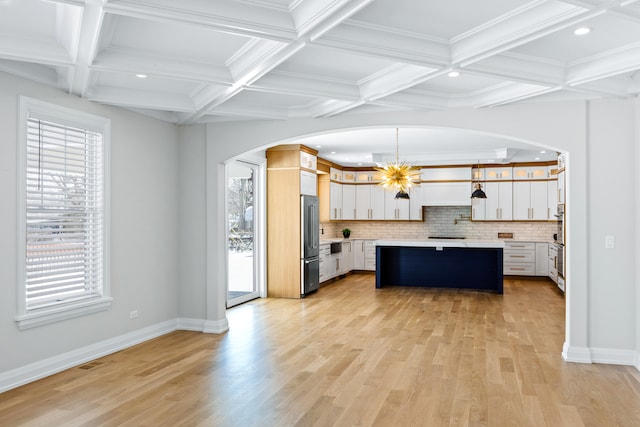 kitchen featuring a kitchen island, white cabinets, pendant lighting, appliances with stainless steel finishes, and tasteful backsplash