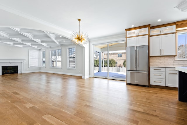 kitchen with high end refrigerator, hanging light fixtures, white cabinetry, light hardwood / wood-style floors, and coffered ceiling