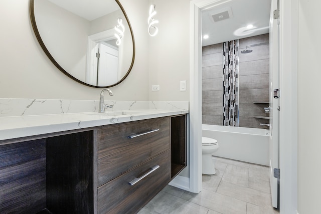 full bathroom featuring vanity, toilet, tiled shower / bath combo, and tile patterned flooring