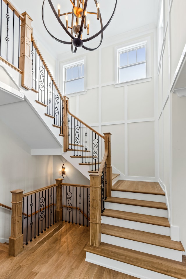 stairway featuring hardwood / wood-style floors and a chandelier