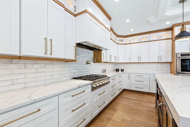 kitchen featuring appliances with stainless steel finishes, decorative light fixtures, and white cabinets