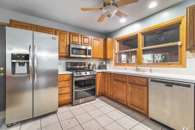 kitchen featuring tasteful backsplash, stainless steel appliances, sink, and light tile patterned floors