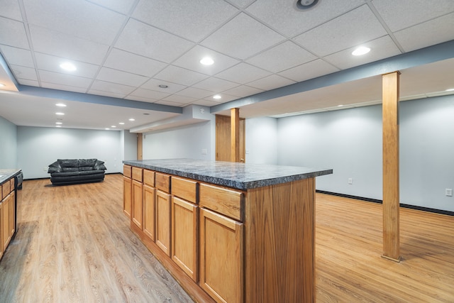 kitchen featuring a drop ceiling, a center island, and light hardwood / wood-style floors