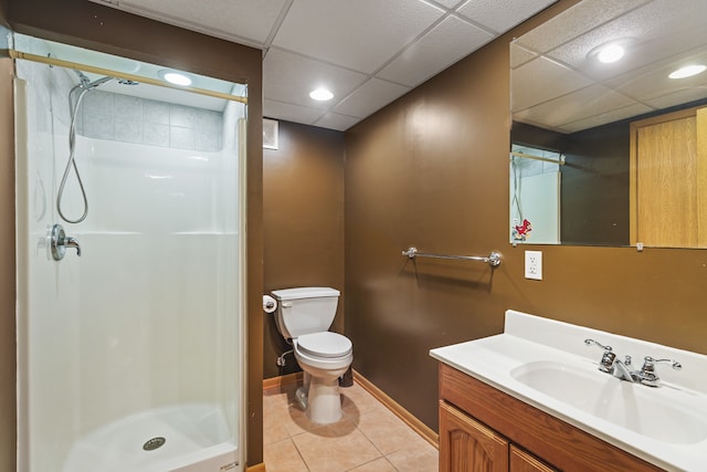 bathroom with toilet, a paneled ceiling, tile patterned floors, vanity, and a shower