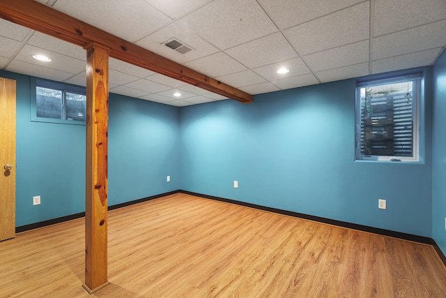 basement featuring light hardwood / wood-style flooring and a drop ceiling