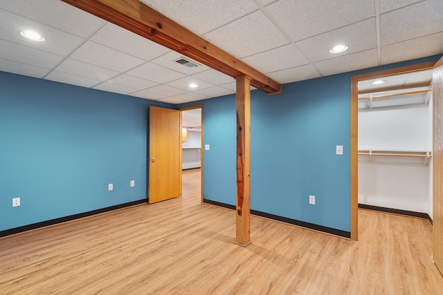 basement with a drop ceiling and light wood-type flooring