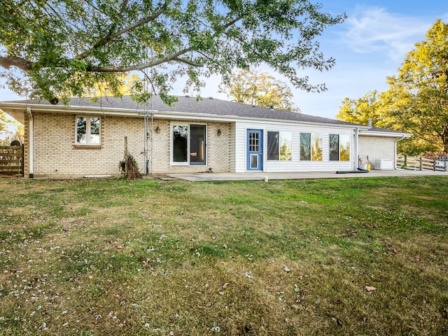 back of property with a patio area and a yard