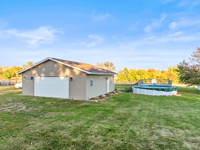 view of side of property with a yard, a covered pool, an outbuilding, and a garage