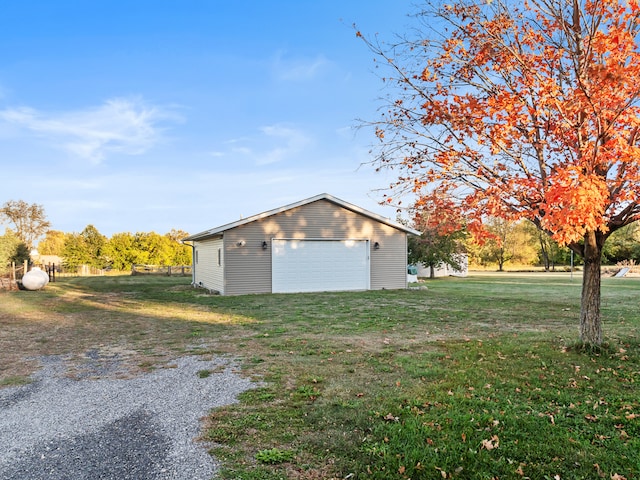 view of side of property featuring an outdoor structure, a lawn, and a garage