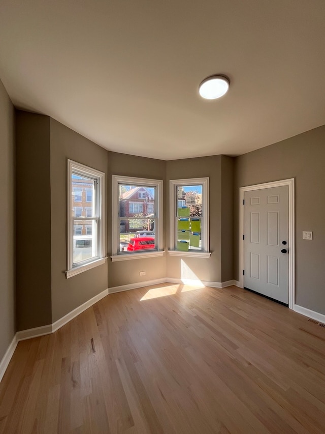 empty room with light hardwood / wood-style flooring