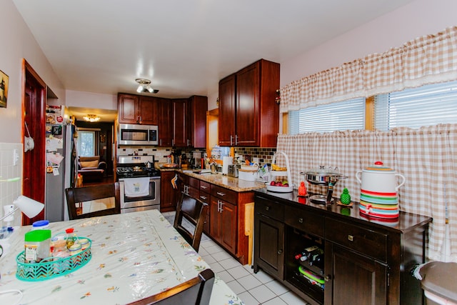 kitchen with stainless steel appliances, tasteful backsplash, and light tile patterned flooring