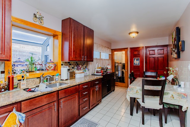 kitchen with light stone countertops, sink, tasteful backsplash, and light tile patterned floors