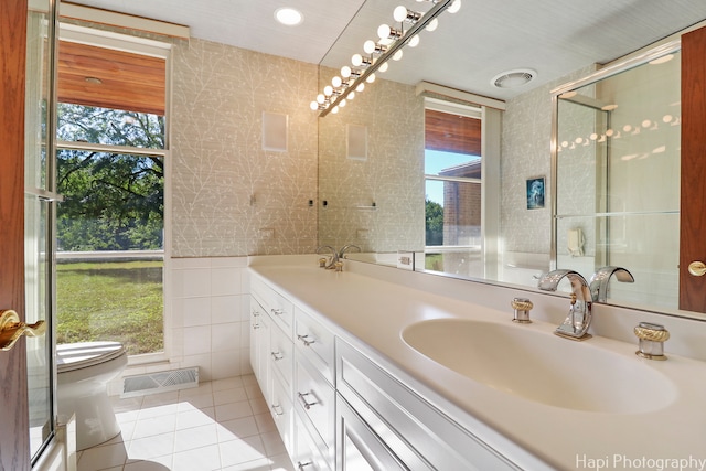 bathroom with a wealth of natural light, vanity, toilet, and tile patterned floors