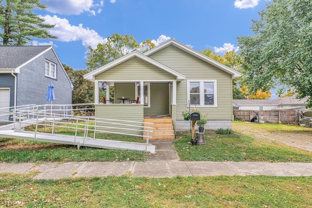 bungalow-style home featuring a porch, a front lawn, and a garage