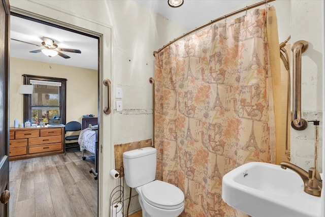 bathroom with sink, a shower with shower curtain, hardwood / wood-style floors, ceiling fan, and toilet