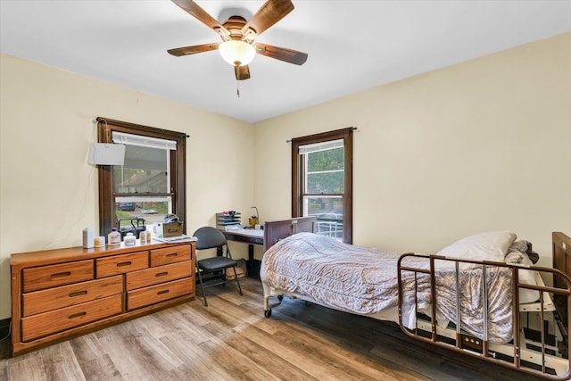 bedroom with light hardwood / wood-style flooring, multiple windows, and ceiling fan