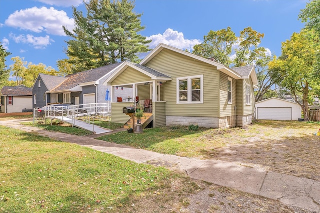 bungalow-style home with a front yard, a porch, an outbuilding, and a garage