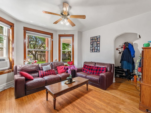 living room featuring ceiling fan, cooling unit, and light hardwood / wood-style flooring