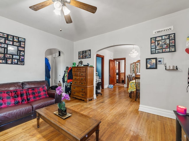 living room with hardwood / wood-style flooring and ceiling fan with notable chandelier