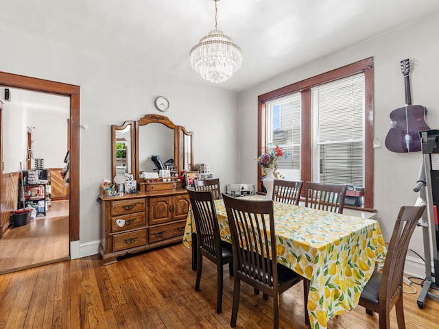 dining room with hardwood / wood-style flooring and an inviting chandelier