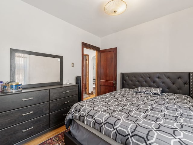 bedroom with vaulted ceiling and light wood-type flooring