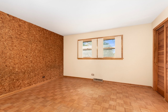 unfurnished bedroom featuring light parquet floors and a closet