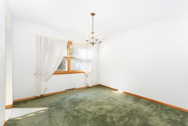 empty room with a chandelier and carpet flooring