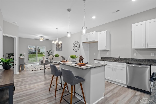 kitchen featuring a kitchen island, white cabinetry, stainless steel dishwasher, light hardwood / wood-style flooring, and sink