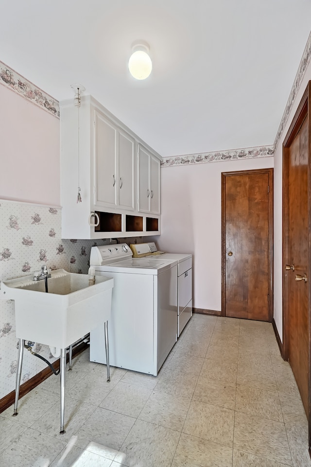 laundry room featuring sink, washer and dryer, and cabinets